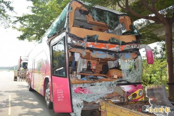 明台高中校車追撞貨櫃車造成車頭嚴重毀損。（記者湯世名攝）