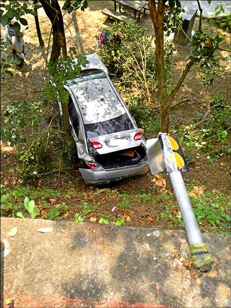 轎車衝破護欄摔落日月潭朝霧碼頭邊坡，幸好車上父子僅受到輕傷。（記者劉濱銓翻攝）