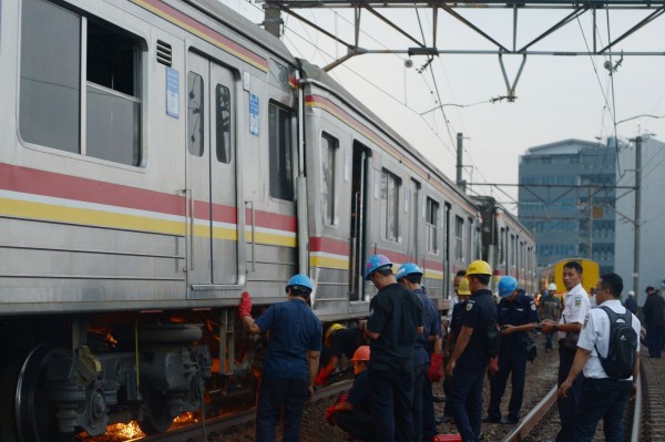 印尼發生火車對撞事故，車廂扭曲甚至出軌，一度造成交通癱瘓，至少35人受傷送醫，工人正在努力搶修。（法新社）