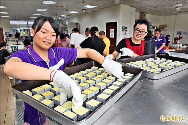 南投仁愛之家志工們分工合作包製愛心月餅。（記者謝介裕攝）