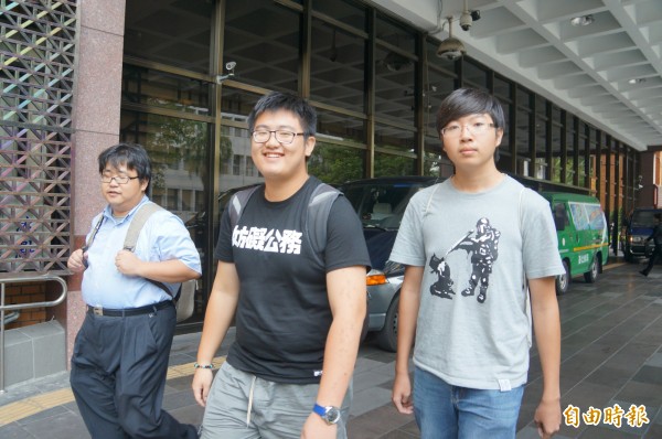 反課綱學生游騰傑（中）、陳柏瑜（右），在律師劉繼蔚（左）陪同下，微笑離開北檢。（記者錢利忠攝）