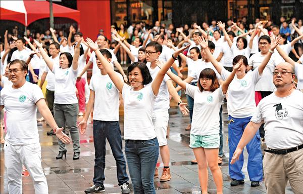 台北市信義區舉辦快閃活動，120人現身香堤大道上高聲歌舞，引來群眾圍觀。（記者張嘉明）