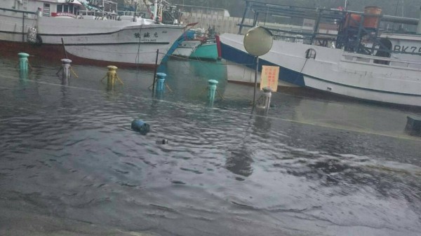 水已將南方澳漁港道路淹沒，防坡柵欄也被風吹毀。（圖由民眾提供）