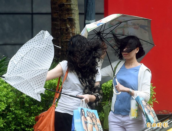 強烈颱風杜鵑接觸台灣陸地，台北市風雨漸強，下午民眾外出時感受颱風威力。（記者方賓照攝）