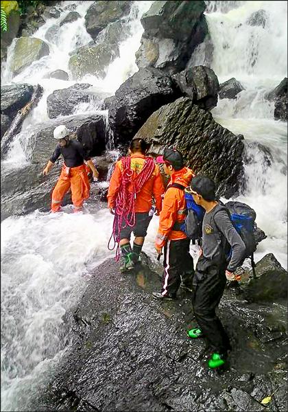 受困新竹縣尖石鄉鎮西堡山區的17名登山客，由搜救隊員護送渡溪，全數平安下山。（新竹縣消防局提供）