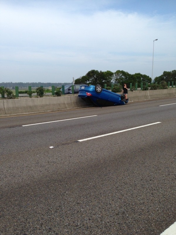 藍車遭碰撞翻覆後，停在內側車道上。（記者鄭鴻達翻攝）