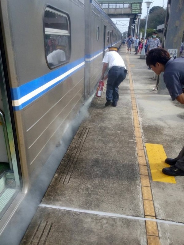 台鐵一輛區間車今天上午停靠苗栗縣竹南鎮崎頂站時，車底突然冒出濃煙。（圖取自臉書社團「爆料公社」）