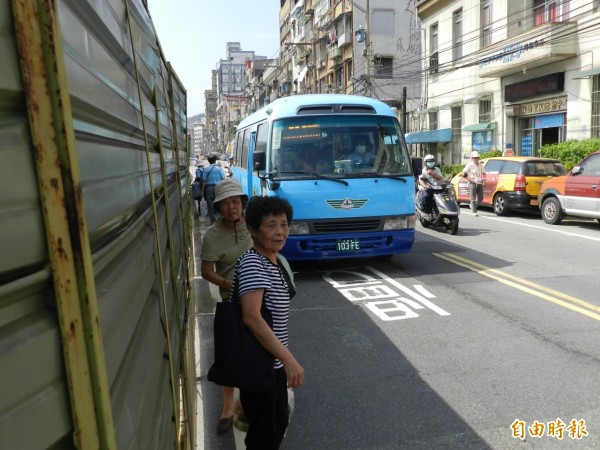 基隆市中山一路進行拓寬工程，施工圍籬緊鄰馬路，造成市民下車後與車爭道，十分危險。（記者俞肇福攝）