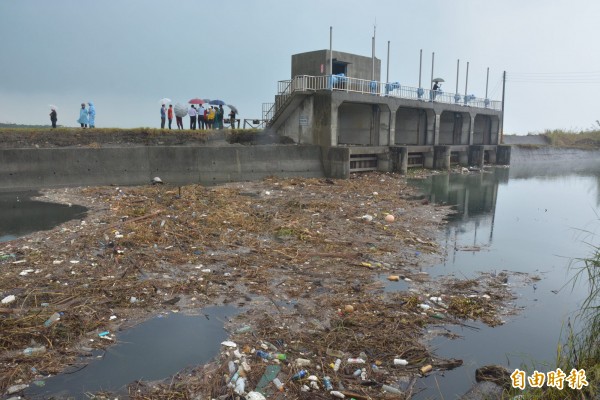 海水淹過海堤，許多垃圾、漂流木淤積在河道上，發出陣陣惡臭。（記者朱則瑋攝）