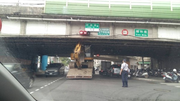 民眾拍下拖板車卡橋下，模樣囧爆。（記者徐聖倫翻攝）

