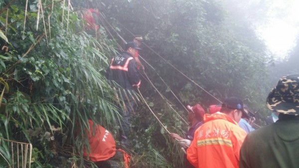 警消人員步行上山並以繩索吊掛作業救出甘女，但甘女因頭部撕裂傷與多處骨折傷重不治。（記者邱芷柔翻攝）