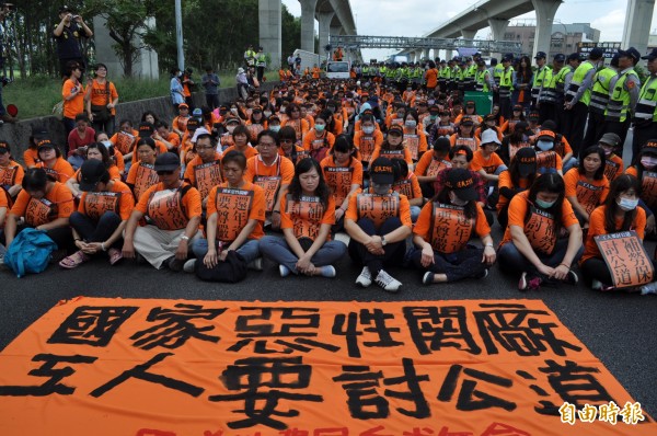  國道收費員自救會成員們去年10月間佔領中山高速公路內壢北上路段的外側二車道後席地而坐，提出要求交通部長葉匡時出面的要求。（資料照，記者周敏鴻攝）