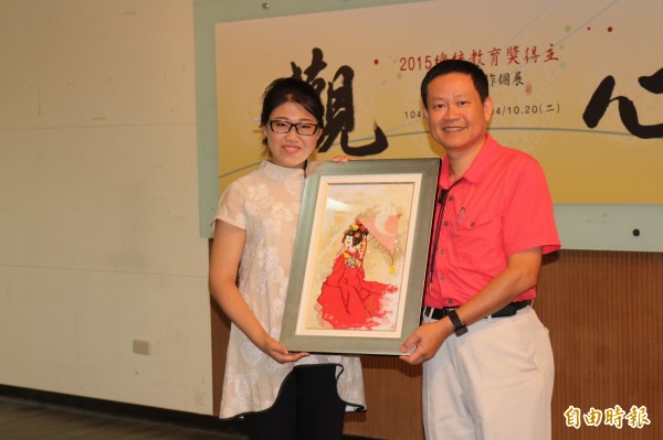 獲得總統教育獎的李佳鎂（左）在母校環球科大開畫展，贈畫作給學校，由校長許舒翔（右）收下。（記者詹士弘攝）