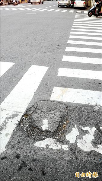 草屯鎮芬草路一段近忠孝街口，路面有坑洞，機車騎士經過若不注意容易出狀況。（記者陳鳳麗攝）