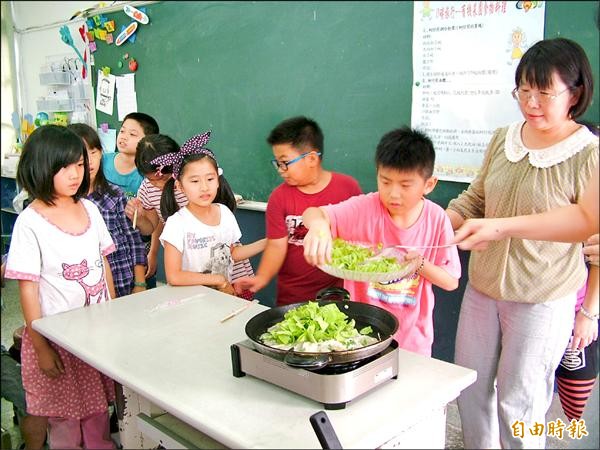 東勢國小學童用自己栽種的小白菜，在教室內煎蚵仔煎加菜。（記者鄭旭凱攝）