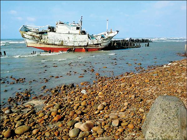 宜蘭籍漁船擱淺在桃園海岸邊。（記者邱奕統翻攝）