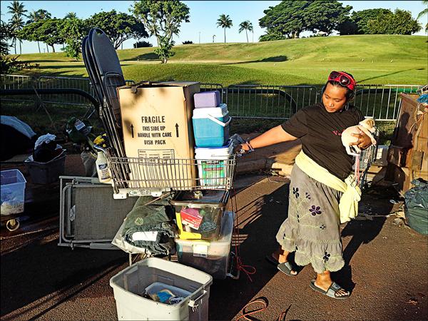 女街友抱著愛犬、拖著全身家當，思索下一步何去何從。（美聯社）