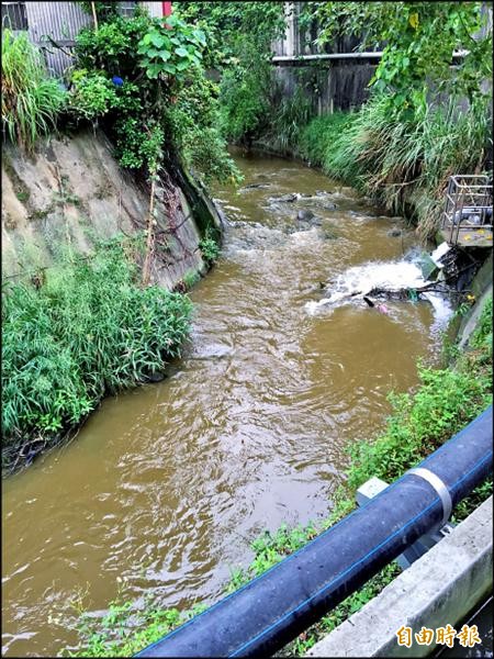 潭子區潭富路二段四張犁支線大排排水竟呈現鏽黃色，居民懷疑為上游工廠利用雨天偷排廢水。（記者歐素美攝）