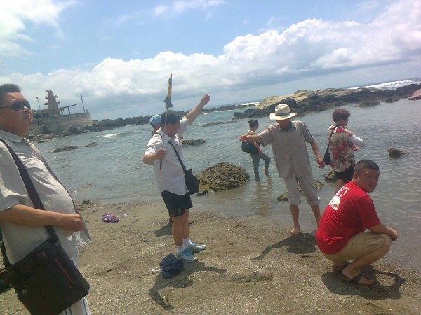 離譜遊客竟然拿導遊旗當釣竿，在杉原海邊釣魚。（保育志工陳世岳提供）