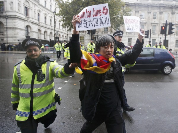 六四民運人士邵江，在英國舉標語抗議時遭警方粗暴逮捕，甚至隔天警方還到他家裡查扣電腦等物品。（路透）