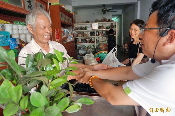 李俊俋（右）沿著民族路跟店家拜票請託。（記者王善嬿攝）