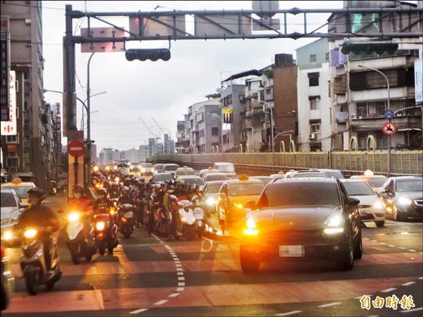 下班尖峰時段，福和橋下橋處汽機車交錯使用，容易衍生事故，市府擬明年初動工取消汽車右轉道。（記者翁聿煌攝）