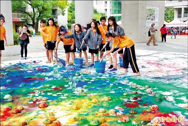 新北藝術教育嘉年華登場，學生們也在大型畫布上彩繪，潑灑顏料為台灣「上色」。（記者陳韋宗攝）