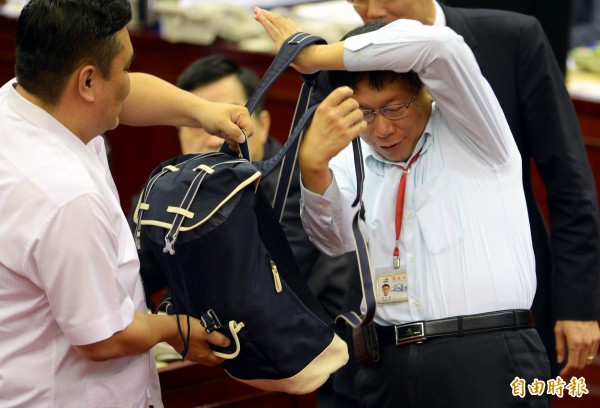台北市長柯文哲備詢時，試背議員帶來模擬學童書包重量的書包。（記者林正方方土攝）