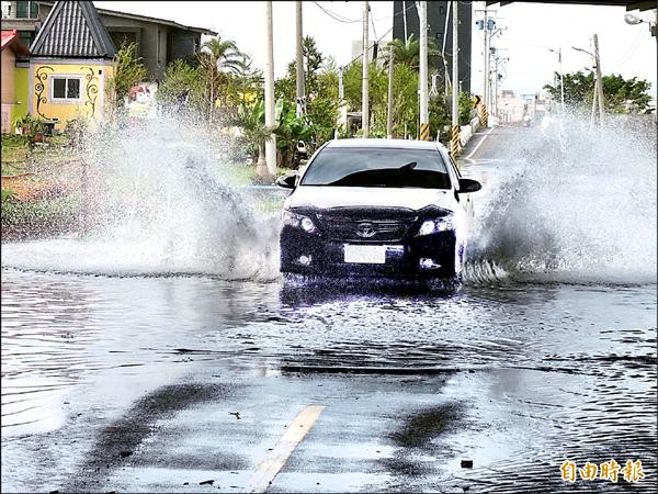 五結鄉低漥路面淹水，車輛經過時水花四濺，宛如陸上行舟。（記者江志雄攝）