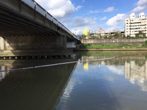 北市環保局及中油在基隆河設攔油索及吸油索防堵。（台北市環保局提供）