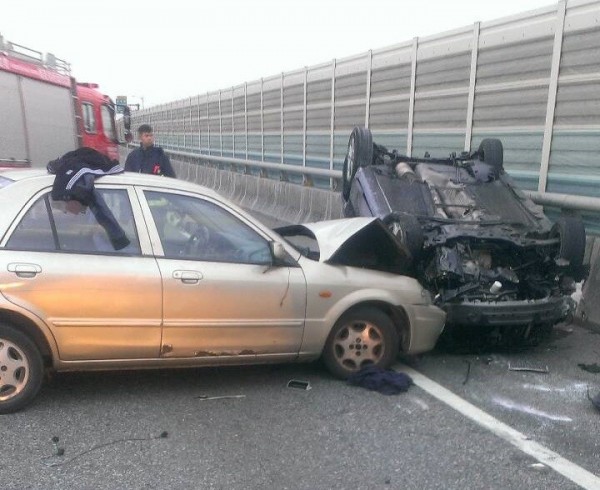 2車擦撞後黑車翻覆，銀車車頭近乎全毀。（記者黃捷翻攝）
