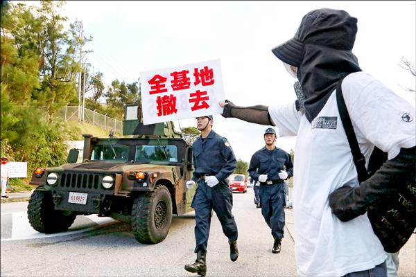 日本政府十七日起訴沖繩縣政府，展現推動邊野古填海造陸工程的決心，反基地民眾再度聚集在美軍史瓦布基地前抗議。（歐新社）