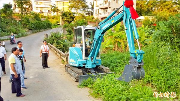 王茜霈昨開怪手幫忙圳頭里民剷除野溪旁雜草。（記者丁偉杰攝）