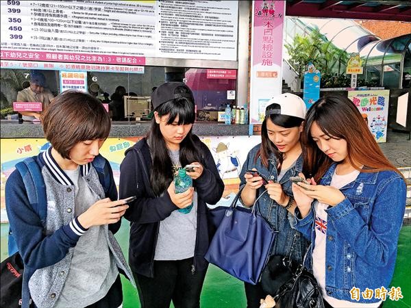 雲科大四位女學生一早到劍湖山世界，以手機要下載優惠券，但活動網頁大塞車，四人等了近二小時才成功入園。（記者黃淑莉攝）