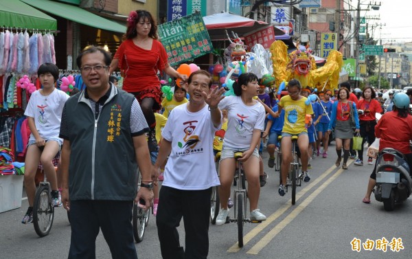 烏日國小慶祝百年校慶，校長林秋發（右一揮手者）、烏日區長林峰輝（右二）今天帶領師生舉辦千人踩街。（記者陳建志攝）