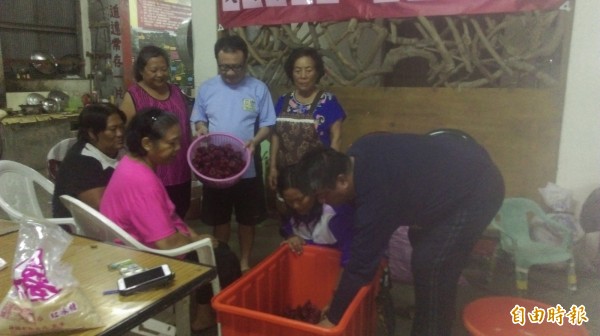 前立委賴坤成（捧籃者）今晚在土坂教原住民製作洛神蜜餞，獲封「賴洛神」。（記者黃明堂攝）