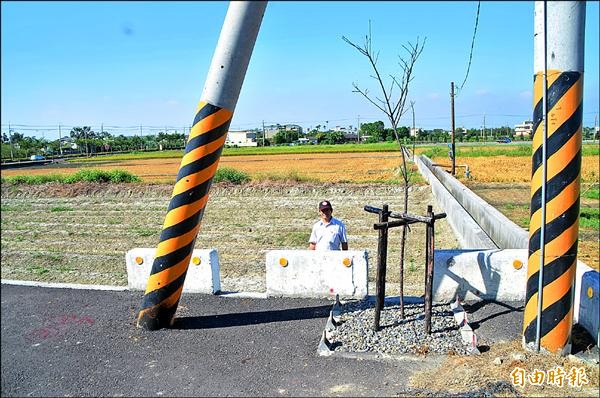 外三塊厝農地重劃，農民田地與道路有落差加上電桿擋道，無法做斜坡，農機無法下田。（記者顏宏駿攝）