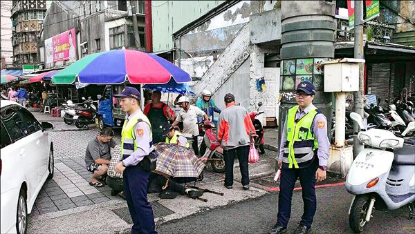 92歲老翁大雨跌倒，攤販拿出千萬級大傘罩著他，避免他遭雨襲失溫。（記者吳政峰翻攝）