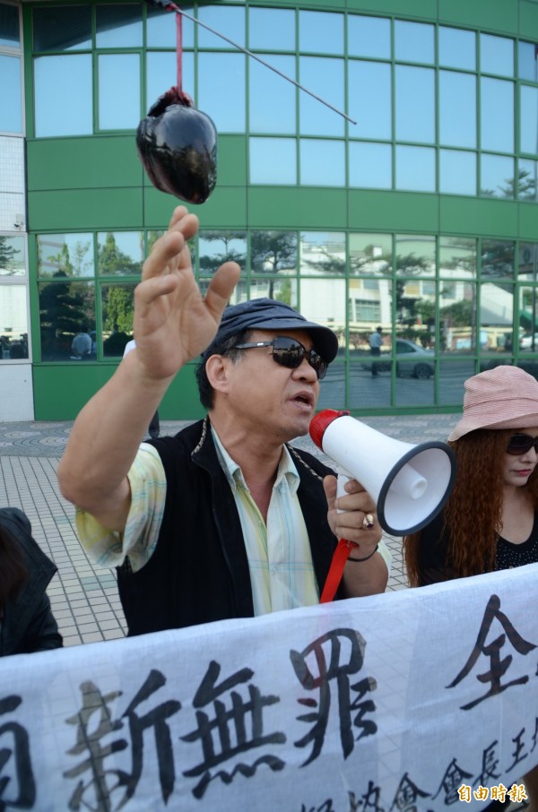 不滿頂新被判無罪,王坤盛吊「黑豬心」,到頂新製油總部丟雞蛋抗議。(記者顏宏駿攝) 不滿頂新被判無罪,王坤盛吊「黑豬心」,到頂新製油總部丟雞蛋抗議。(記者顏宏駿攝)
