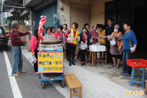 竹北警分局豐田所所長吳榮財（右三）今天早上送附贈的「所長茶葉蛋」到阿嬤的烤地瓜攤，也順便幫她吆喝攬客。（記者黃美珠攝）