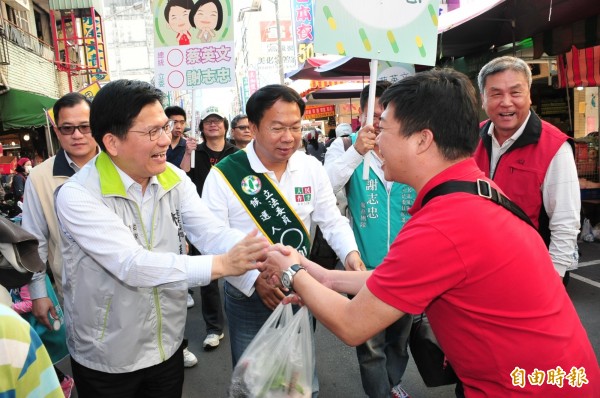 市長林佳龍陪同立委候選人謝志忠到市場拜票，民眾熱情握手。（記者李忠憲攝）