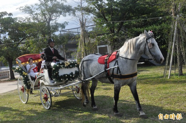 台東縣長黃健庭（右二）今天與慢慢說樂團金曲組合搭馬車傳播耶誕歡樂。（記者黃明堂攝）