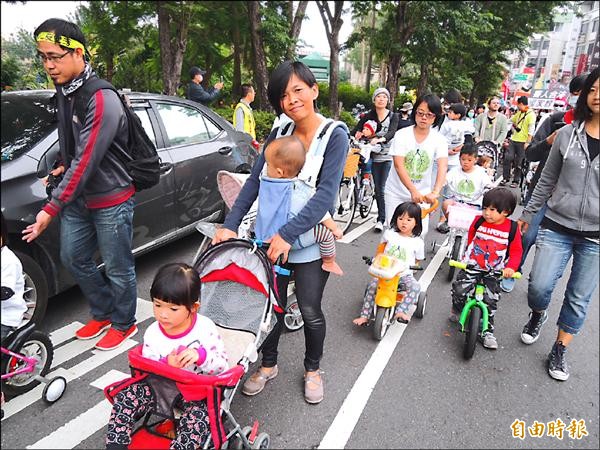 親子出動，一位媽媽「又抱又推」小孩上街頭，爭取下一代生活環境權益。（記者洪瑞琴攝）