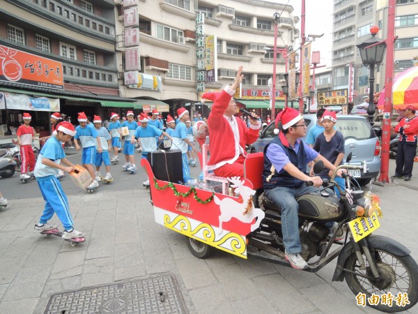 北港建國國中校長林吉城（著紅衣）今扮耶老人，帶領踩蛇板的學生街頭衝浪。（記者陳燦坤攝）