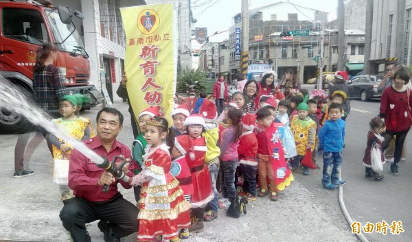 新育人幼童造訪鹽水消防隊，體驗消防水龍，祝福警消伯伯耶誕快樂。（記者王涵平攝）