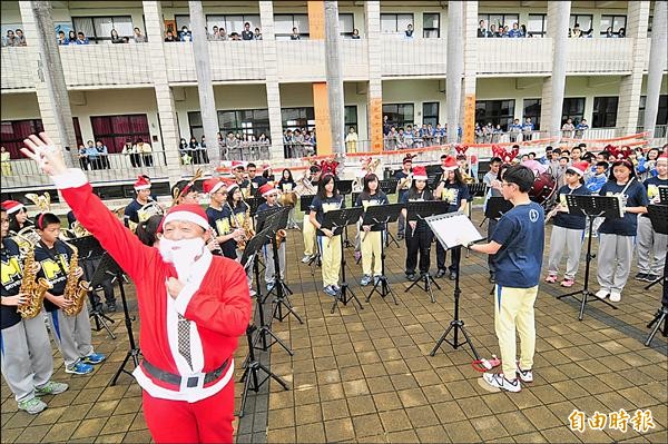 弘文中學管樂團快閃演奏，校長張輝政扮成耶誕老人，在現場跟著節奏揮手。（記者李忠憲攝）