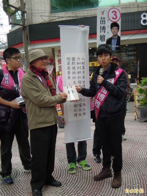 民進黨前主席林義雄陪同第八選區綠社盟立委候選人苗博雅掃街，並贈親筆書法摹本，苗博雅回贈《叛道》一書。（記者梁珮綺攝）