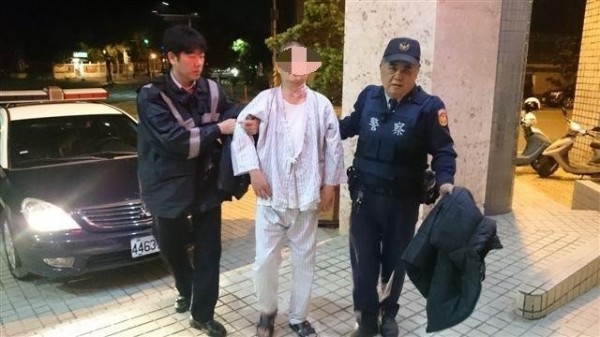 李男（中）穿著病服深夜高雄街頭「趴趴走」，警方將他帶回派出所。（記者方志賢翻攝）