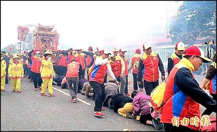 民眾匍匐在地爭相「鑽鑾轎」祈求媽祖庇佑。（記者張聰秋攝）