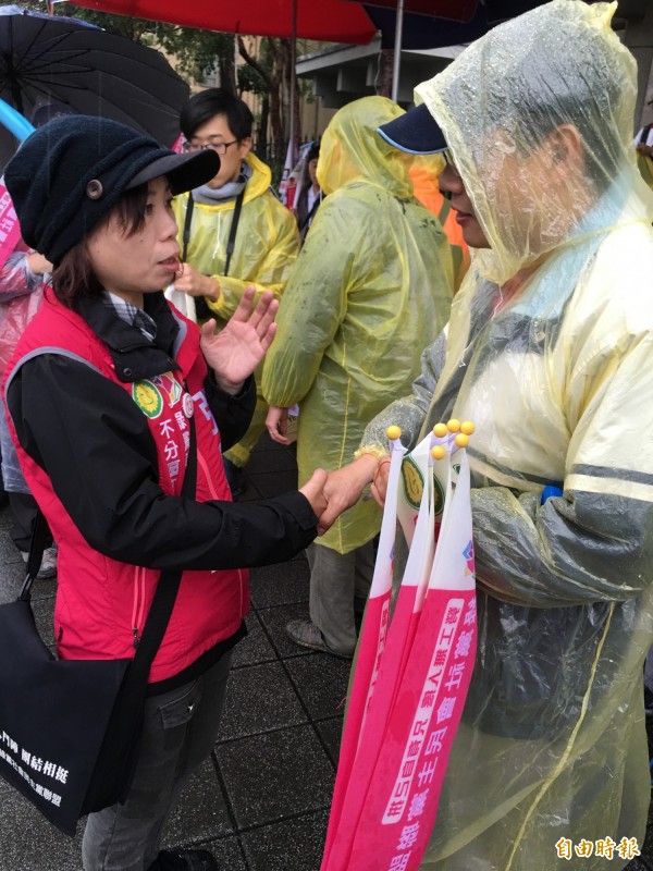 北台工會相挺 綠社盟送勞工進國，其中綠社盟不分區立委第一名張麗芬（左），冒雨幫來參加遊行的勞工加油打氣。（記者陳炳宏攝）